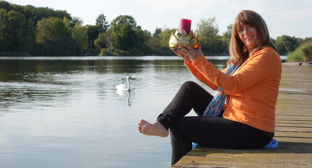 Anja sitzt auf dem Steg am Wasser